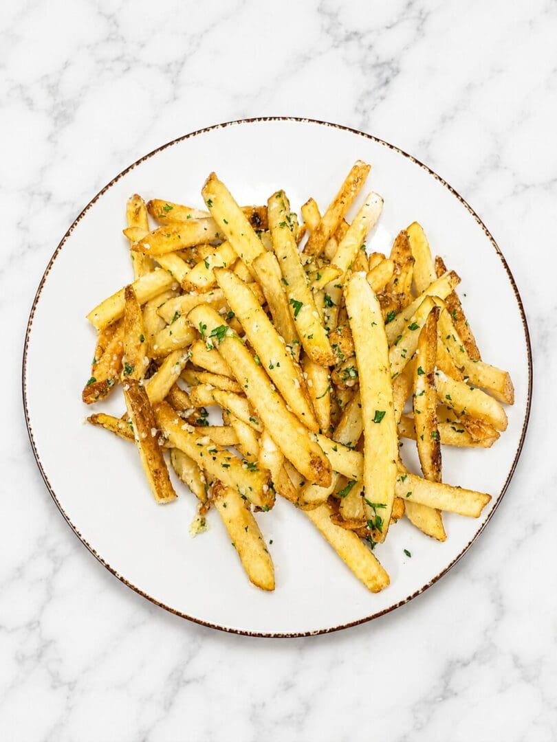 Herbed French fries on marble background plate