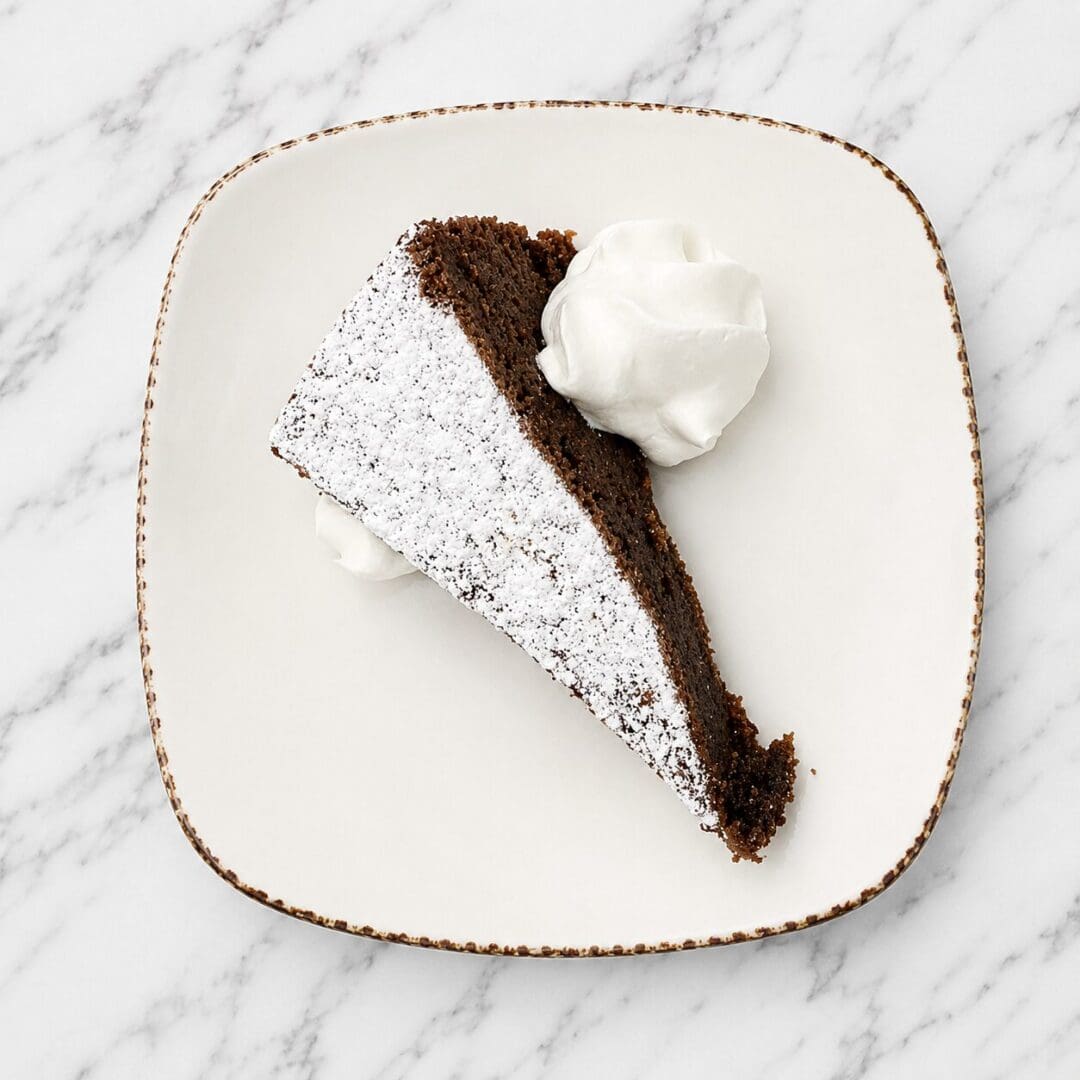 Powdered chocolate cake slice with whipped cream