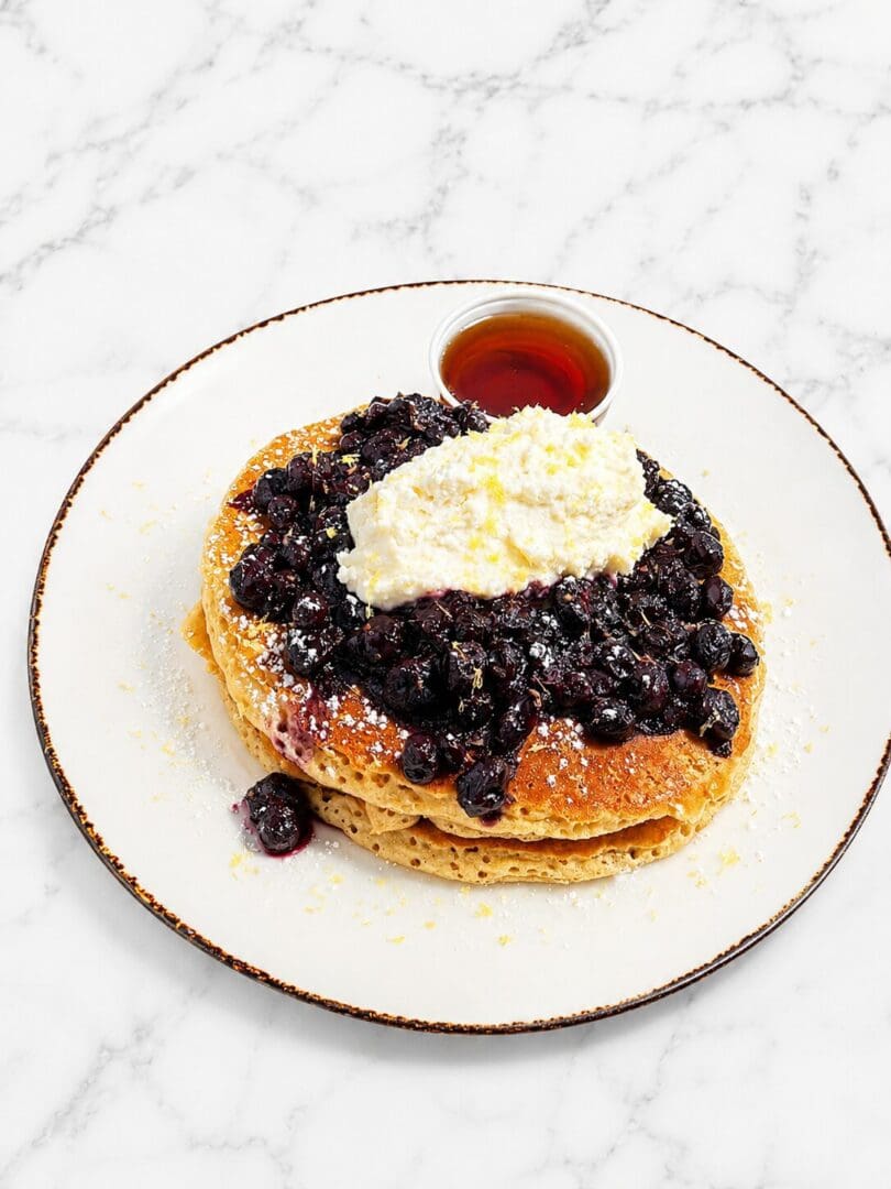 Blueberry pancakes with whipped cream and syrup