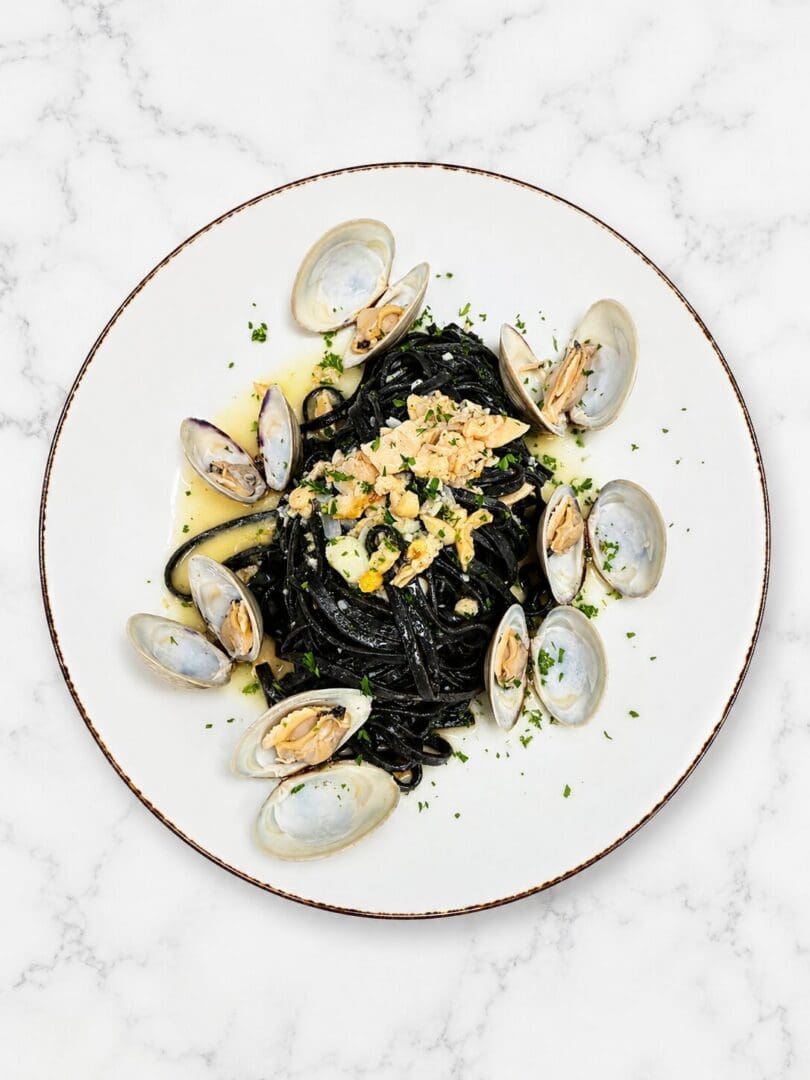 Squid ink pasta with clams on plate
