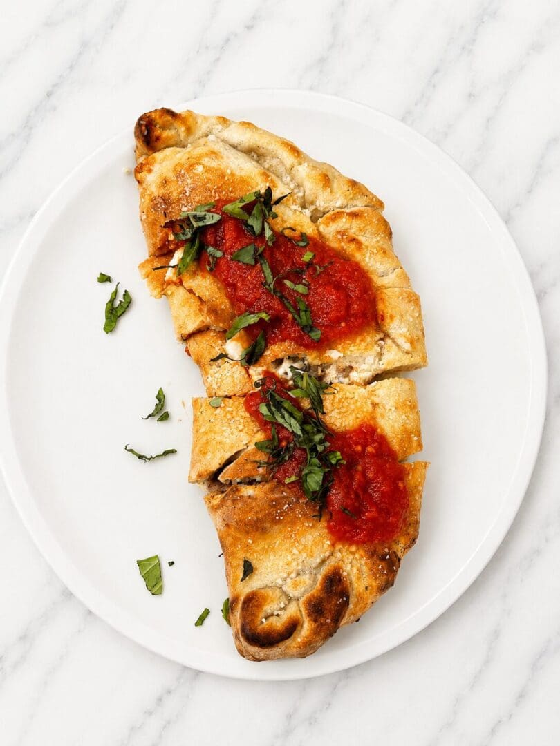 Sliced calzone with tomato sauce and basil