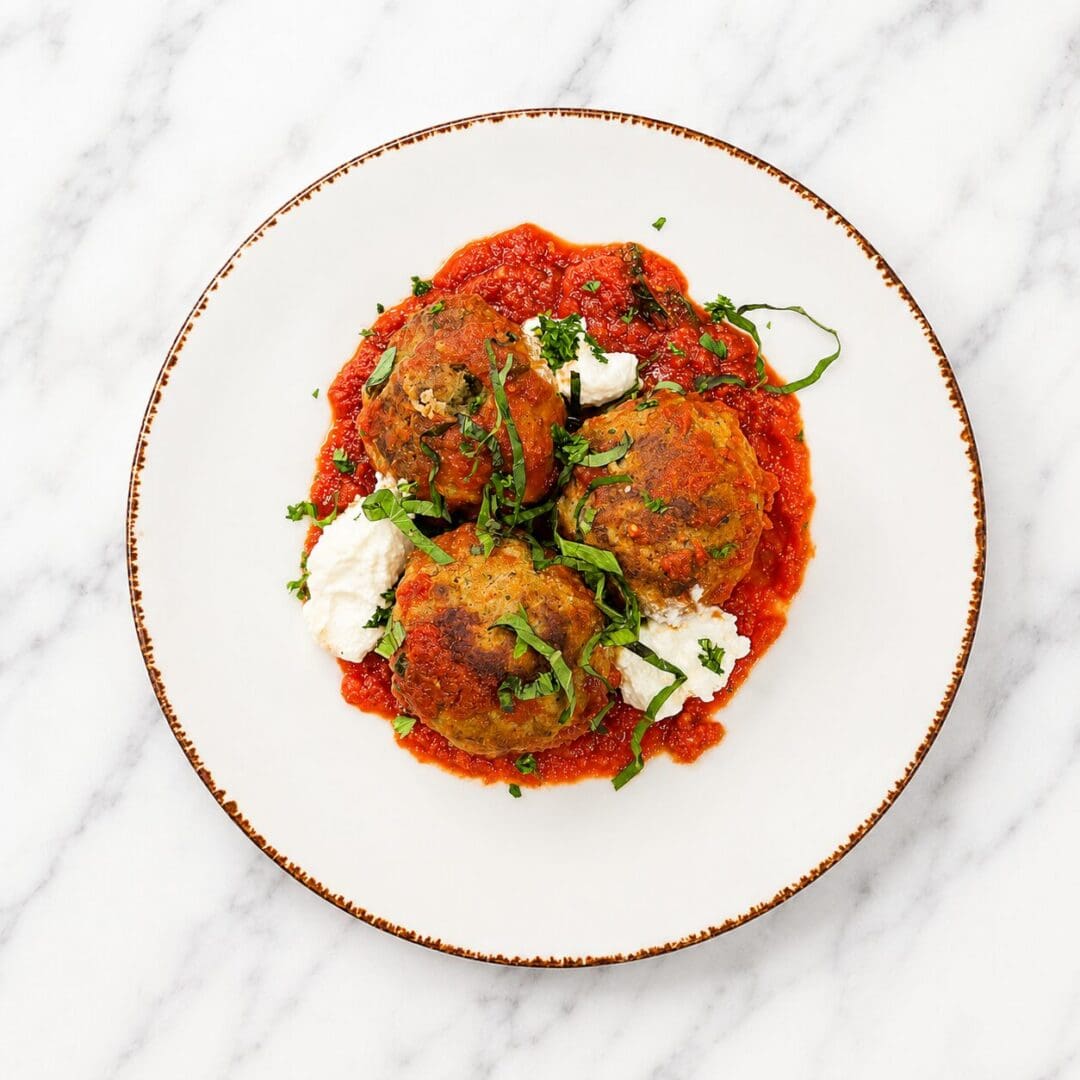 Three meatballs with marinara and ricotta