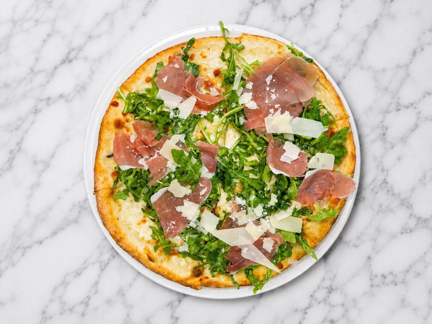 Prosciutto and arugula pizza with shaved parmesan