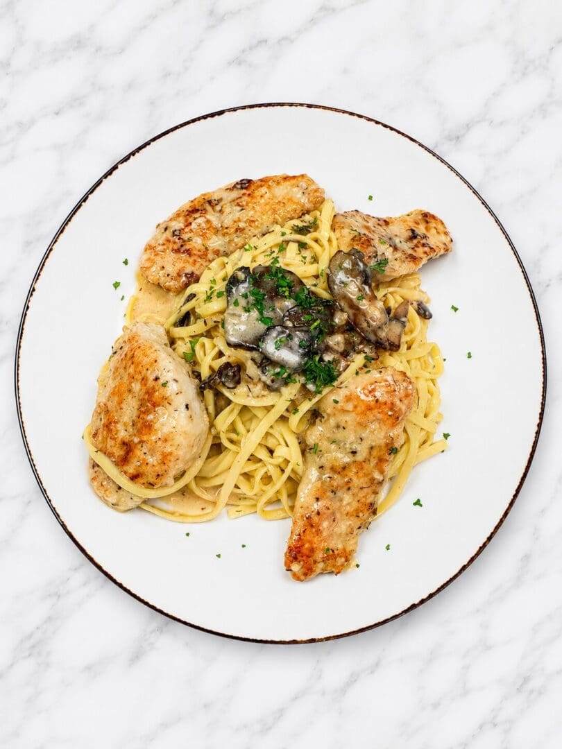 Chicken and mushroom pasta on white plate