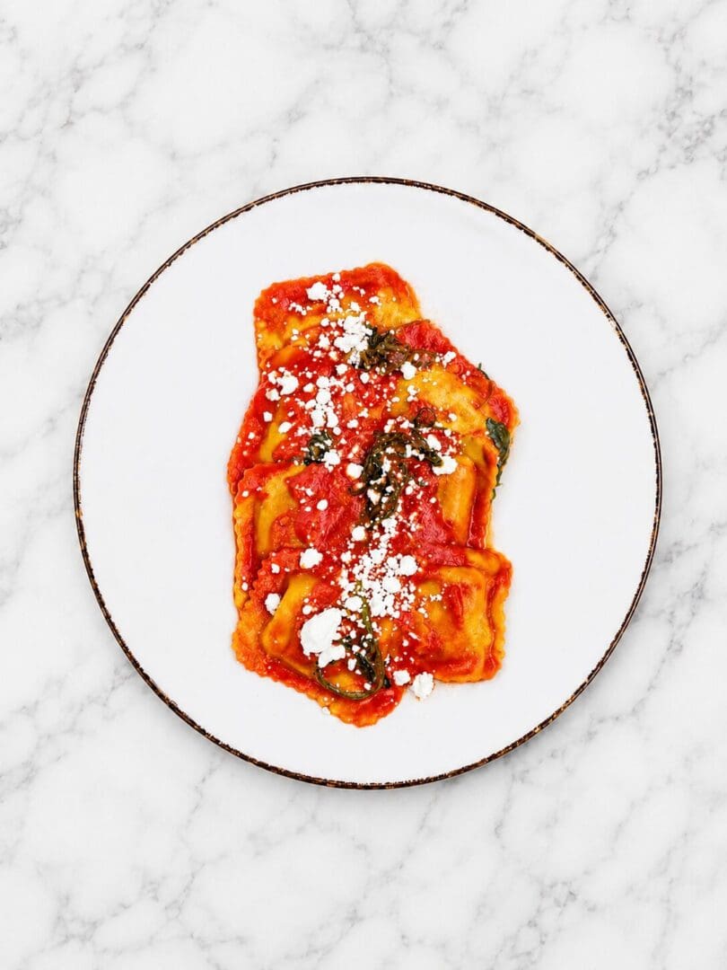 Ravioli topped with tomato sauce and cheese